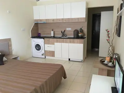 a bedroom with a bed and a sink and a washing machine at Apart Hotel salt Lake in Pomorie