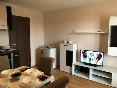 a living room with a table with a tv on it at Palace De Luxe - Apartments in Pomorie