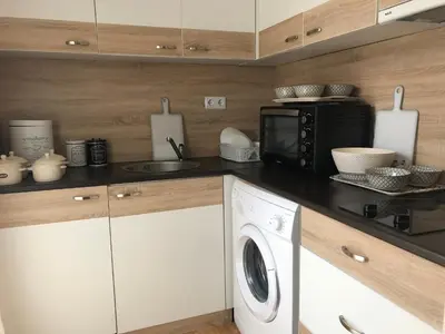 a kitchen with a microwave and a washing machine at Palace De Luxe - Apartments in Pomorie
