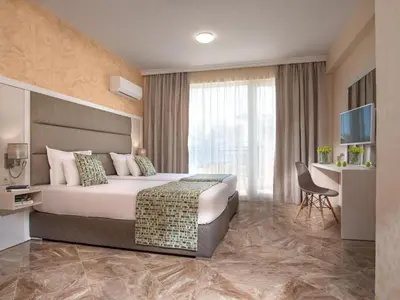 a bedroom with a large bed and a television at Marina Sands Bijou Boutique is an excellent choice for travelers visiting Obzor in Obzor