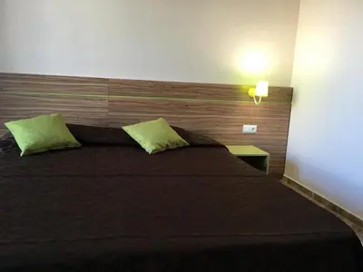 a bedroom with a large bed with a wooden headboard at Flower Street provides accommodations with free Wifi, air conditioning in Sunny Beach
