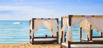 two beds on a beach with the ocean in the background at FORT NOKS NESSEBAR B2-216 Studio SUNNY BEACH in Sunny Beach