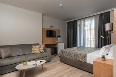 a hotel room with a bed and a couch at Tia Maria is situated in the southern part of the Sunny Beach Resort in Sunny Beach