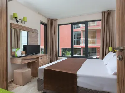 a hotel room with a large bed and a television at Tia Maria is situated in the southern part of the Sunny Beach Resort in Sunny Beach