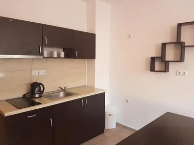 a kitchen with black cabinets and a sink at Salt Lake ApartHotel in Pomorie