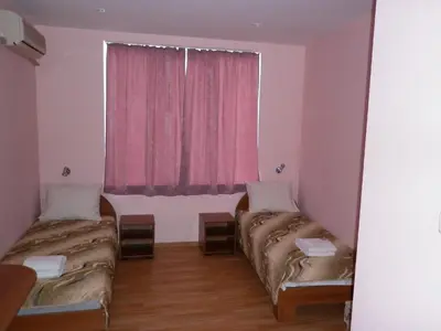two beds in a room with a pink window at Ivanova Cheshma Guest House in Varna City