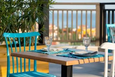 a wooden table with chairs and glasses on a porch at Nevis Resort & Aqua Park - All Inclusive in Sunny Beach