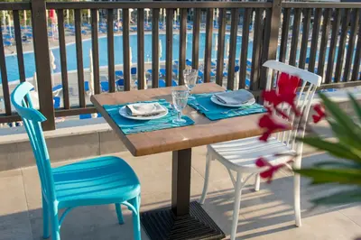 a table and chairs on a balcony next to a pool at Nevis Resort & Aqua Park - All Inclusive in Sunny Beach