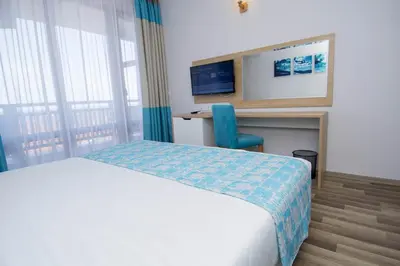 a bedroom with a bed and a desk and a chair at Nevis Resort & Aqua Park - All Inclusive in Sunny Beach