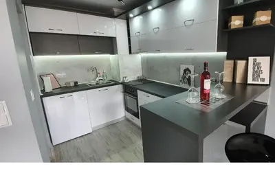 a kitchen with white cabinets and a counter with wine bottles at K&K Stylish Elegance in Burgas City
