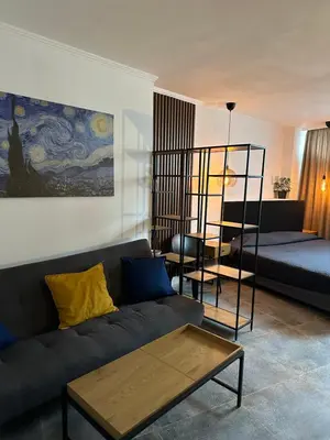 a living room with a couch and a bed at Hotel Art in Varna City