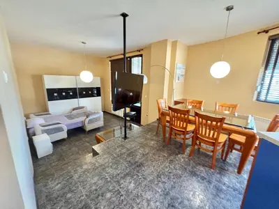 a living room with a table and chairs and a couch at Sun Palace apartments in Sveti Vlas