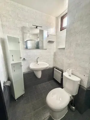 a bathroom with a white toilet and a sink at Sun Palace apartments in Sveti Vlas