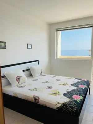 a bedroom with a large bed with a window at Sun Palace apartments in Sveti Vlas