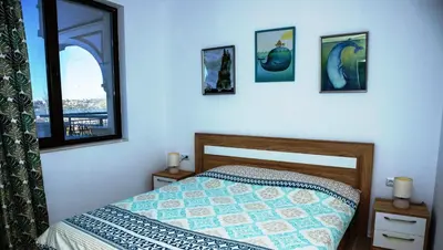 a bedroom with a bed and pictures on the wall at Green Life One-Bedroom Apartment with Sea View by Flаt Manаger in Sozopol