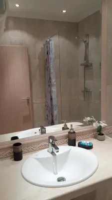 a bathroom with a white sink and a shower at RELAX Apartment in Varna South Bay Residence in Varna City