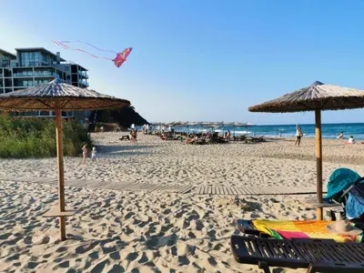 a beach with umbrellas and people on the beach at Marine Beach Sands- All Inclusive in Obzor