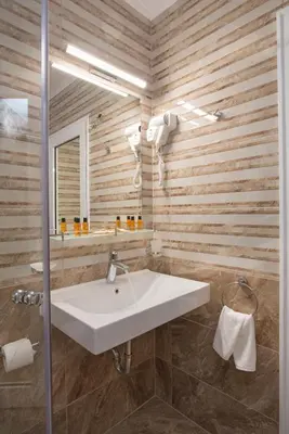 a white sink in a bathroom with wooden walls at Marine Beach Sands- All Inclusive in Obzor