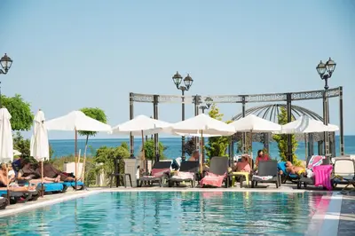 a group of people sitting around a swimming pool at Marine Beach Sands- All Inclusive in Obzor