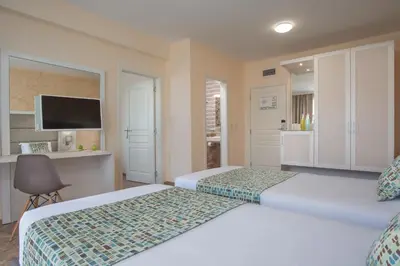a hotel room with two beds and a television at Marine Beach Sands- All Inclusive in Obzor