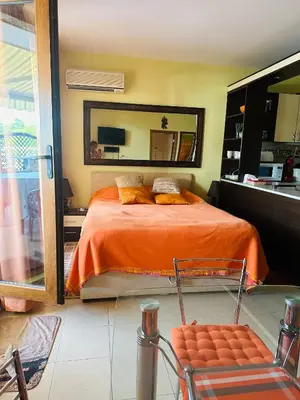 a bedroom with a bed and a large mirror at Аппартамент в Триумфе Святой Влас 300м от моря, бассейн. in Sveti Vlas