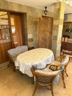 a table and chairs in a room with a stone wall at Аппартамент в Триумфе Святой Влас 300м от моря, бассейн. in Sveti Vlas