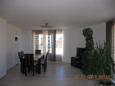 a dining room with a table and chairs and a plant at Incanto Apartments in Sveti Vlas