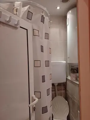 a bathroom with a toilet and a shower curtain at Top Center Apartment and Rooms Varna in Varna City