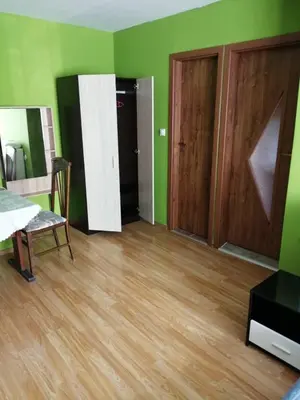 a room with green walls and wooden floors and doors at Top Center Apartment and Rooms Varna in Varna City