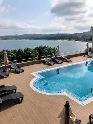 a swimming pool with chairs and a view of the water at Solinaria Boutique Hotel in Sozopol