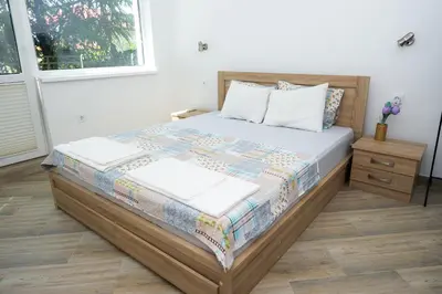 a bedroom with a bed with a wooden frame at Luxury House In Chervenka next to Gradina beach in Chernomorets