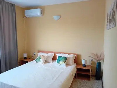 a bedroom with a bed with white sheets and pillows at Solis in Primorsko