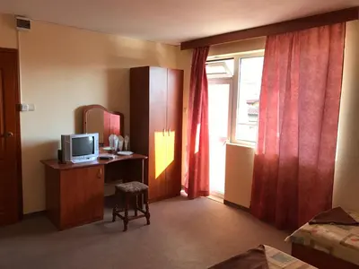 a hotel room with a television and a desk and a window at Solis in Primorsko