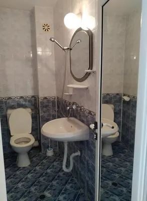 a bathroom with two toilets and a sink and a shower at Solis in Primorsko