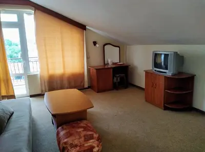 a living room with a couch and a tv at Solis in Primorsko