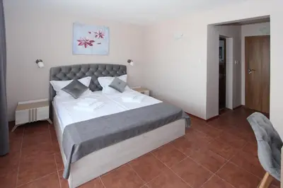 a bedroom with a bed and two chairs at Hotel PERLA BEACH in Sozopol