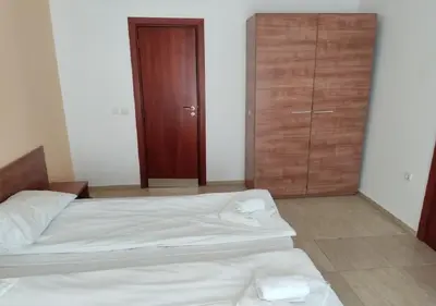 a bedroom with a bed and a wooden cabinet at Debbies 2 bed apart with pool and garden views in Sunny Beach