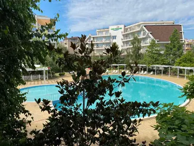 a large blue swimming pool in front of a building at Debbies 2 bed apart with pool and garden views in Sunny Beach