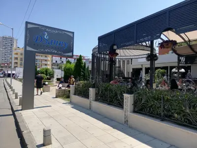 a sign for a restaurant on a city street at Debbies 2 bed apart with pool and garden views in Sunny Beach