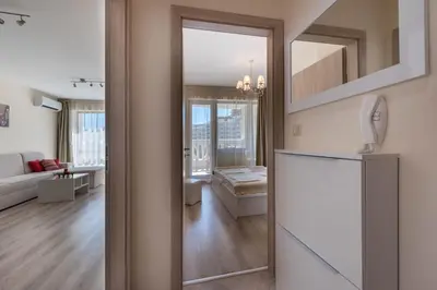 a kitchen with a refrigerator and a living room at Blue Lagoon Seafront Apartments in Varna City