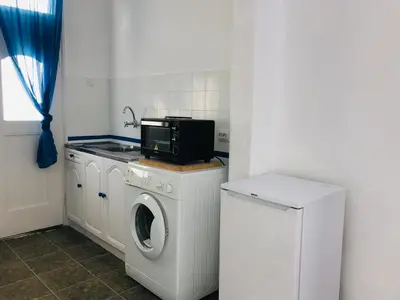 a kitchen with a washing machine and a microwave at Къща Наде in Tsarevo