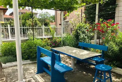 a blue table and two blue chairs in a garden at Къща Наде in Tsarevo