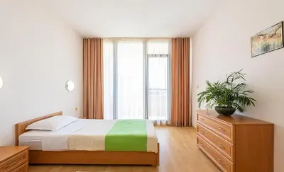 a bedroom with a bed and a large window at Apartment in Trakia Plaza complex in Sunny Beach