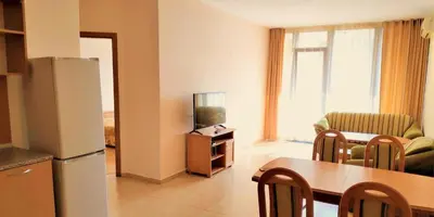a kitchen and living room with a refrigerator and a table at Apartment in Trakia Plaza complex in Sunny Beach