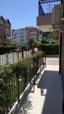 a black fence with flowers next to a sidewalk at Complex Argo ap.2 in Ravda