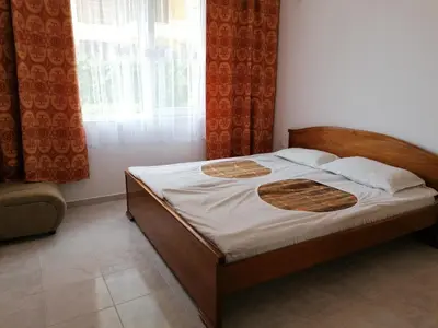 a bed with a wooden frame in a bedroom at Complex Argo ap.2 in Ravda