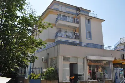 a tall white building with blue balconies on it at Апартамент Одеса 22 in Sozopol