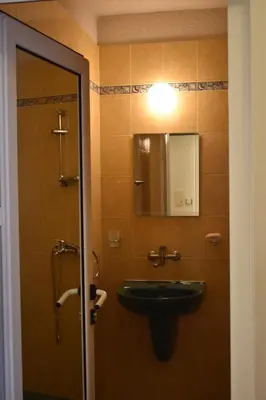 a bathroom with a sink and a light on the door at Апартамент Одеса 22 in Sozopol