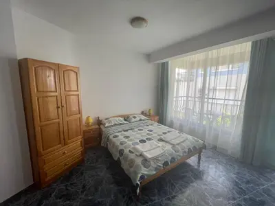 a bedroom with a bed and a large window at Студио Одеса 22 in Sozopol