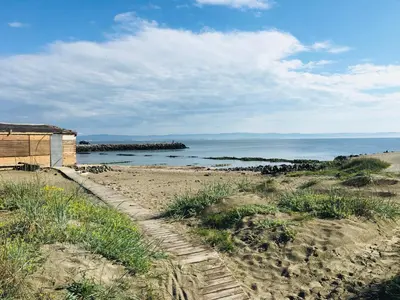 a sandy beach with a building and the ocean at Rent Apartments Martin Beach in Pomorie